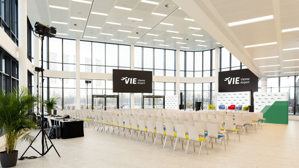 Konferenzraum Runway 1 mit Theaterbestuhlung, LED-Wänden und Bühne, bereit für eine Veranstaltung.